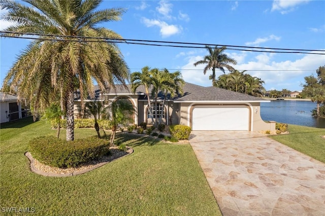 view of front of property featuring a water view, a front yard, and a garage