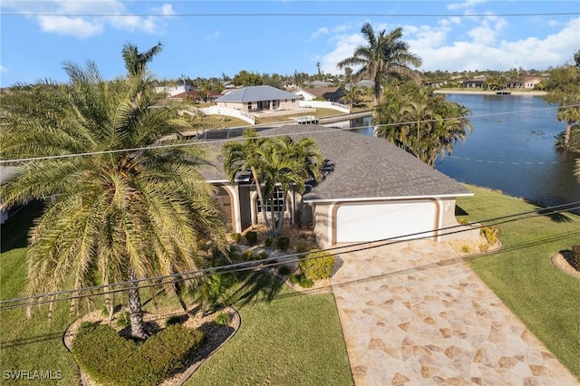 view of front facade with a water view, a garage, and a front lawn