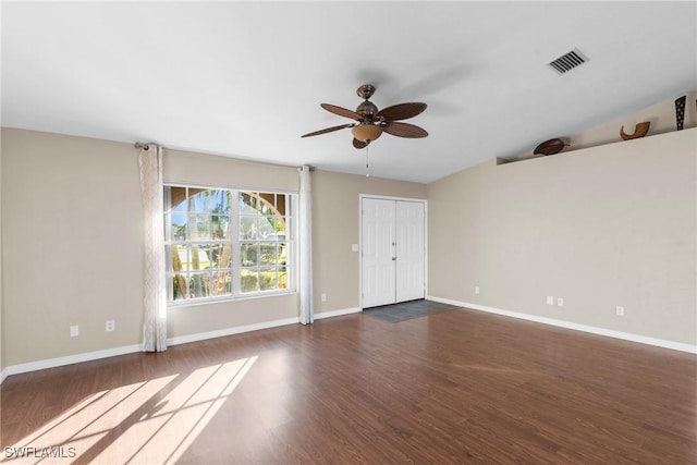 spare room featuring ceiling fan, dark hardwood / wood-style flooring, and vaulted ceiling