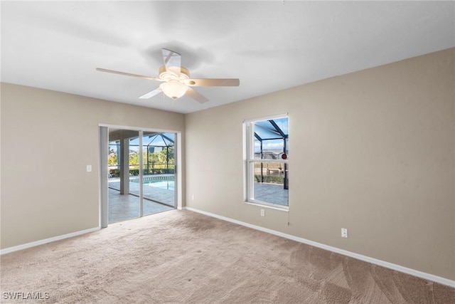 carpeted spare room featuring plenty of natural light and ceiling fan