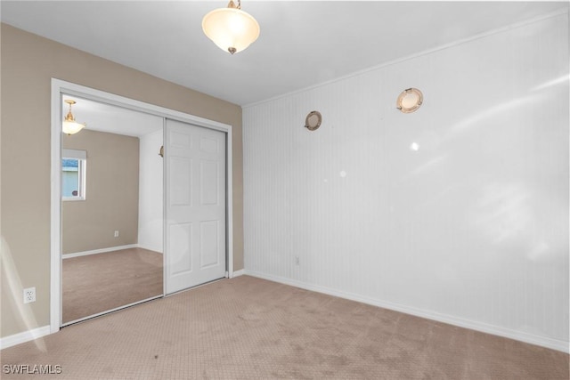 unfurnished bedroom with light carpet and a closet