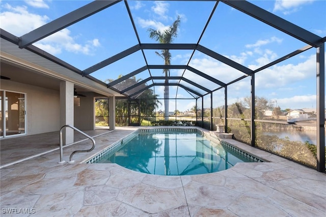 view of swimming pool with glass enclosure, a patio area, and a water view