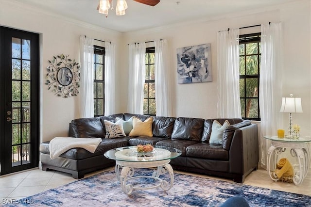 tiled living room with ceiling fan and ornamental molding