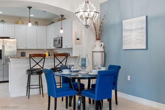 dining space with light tile patterned flooring, sink, crown molding, and a chandelier