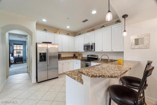 kitchen with kitchen peninsula, white cabinets, stainless steel appliances, and decorative light fixtures