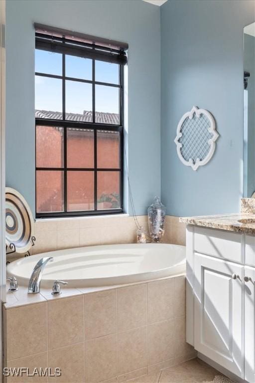 bathroom featuring vanity, tiled bath, and tile patterned floors