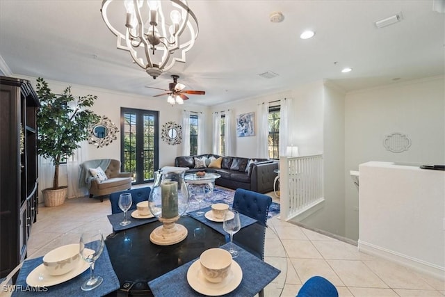 tiled dining space with ceiling fan with notable chandelier and ornamental molding