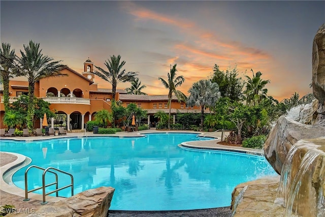 pool at dusk featuring a patio area