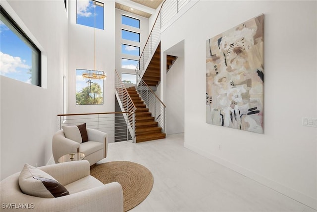 interior space featuring a healthy amount of sunlight, a towering ceiling, and an inviting chandelier