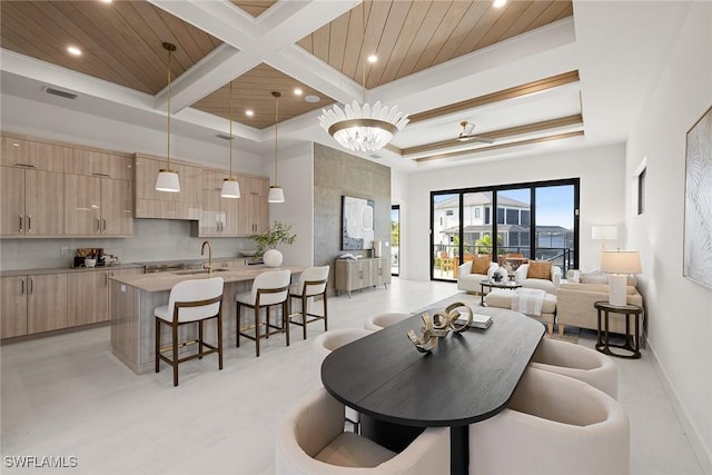 living room with wooden ceiling, sink, a towering ceiling, a notable chandelier, and beam ceiling