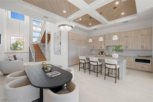 interior space with beamed ceiling, a high ceiling, coffered ceiling, and wood ceiling