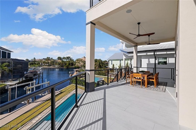 balcony with ceiling fan and a water view