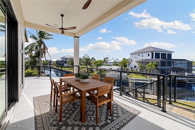 balcony with ceiling fan and a water view