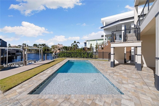 view of pool with a patio area, a dock, and a water view