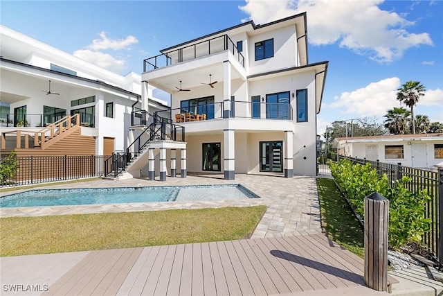 back of property with a fenced in pool, ceiling fan, a balcony, and a patio