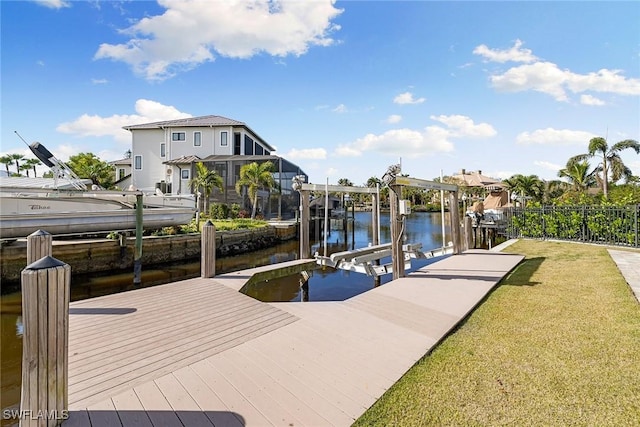 view of dock with a water view and a lawn