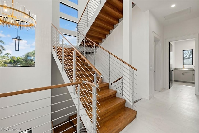 stairs featuring a chandelier