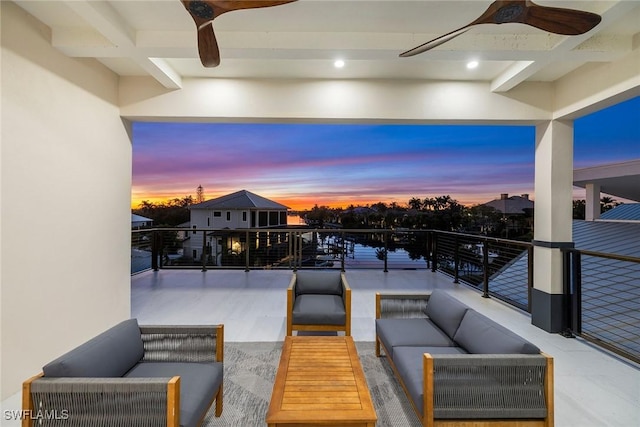 patio terrace at dusk featuring ceiling fan and an outdoor living space