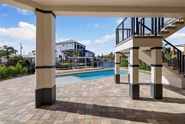 view of pool featuring a patio and a water view