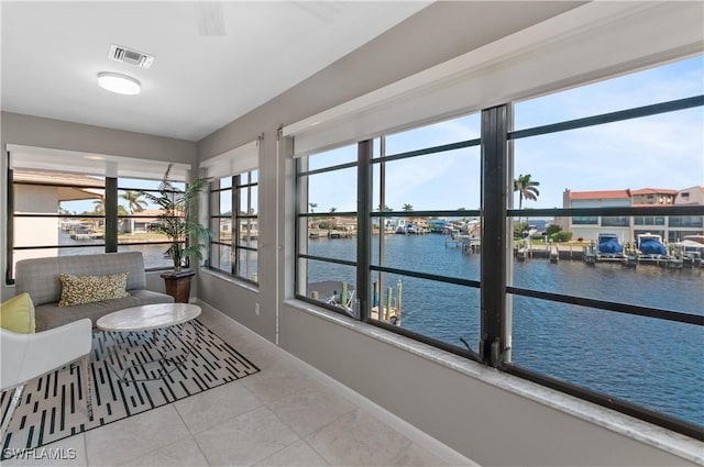 sunroom featuring a water view and a wealth of natural light