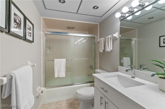 bathroom with visible vents, toilet, tile patterned floors, combined bath / shower with glass door, and vanity