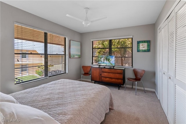 bedroom featuring a closet, multiple windows, baseboards, and carpet floors