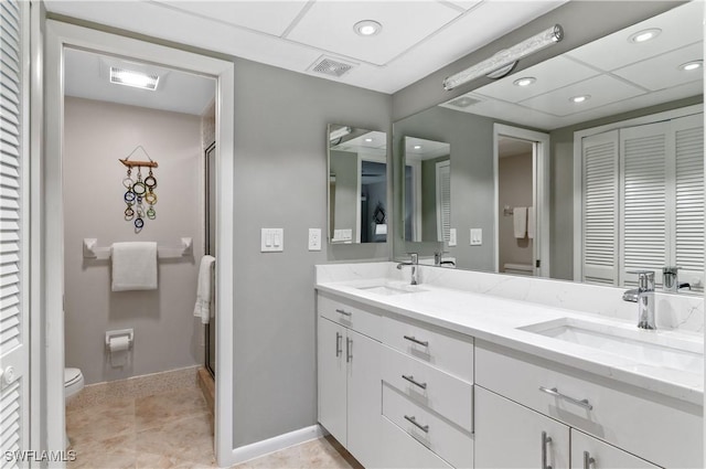 bathroom featuring tile patterned floors, toilet, vanity, and walk in shower