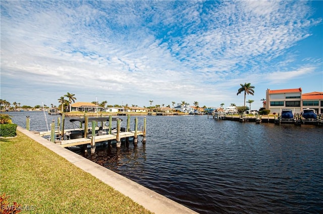 view of dock with a yard and a water view