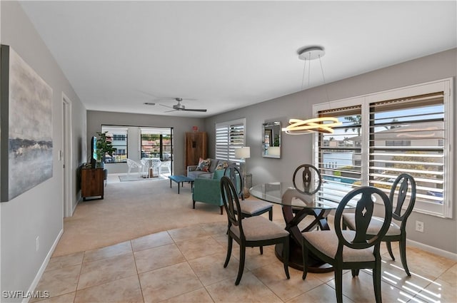 carpeted dining area featuring ceiling fan and a water view