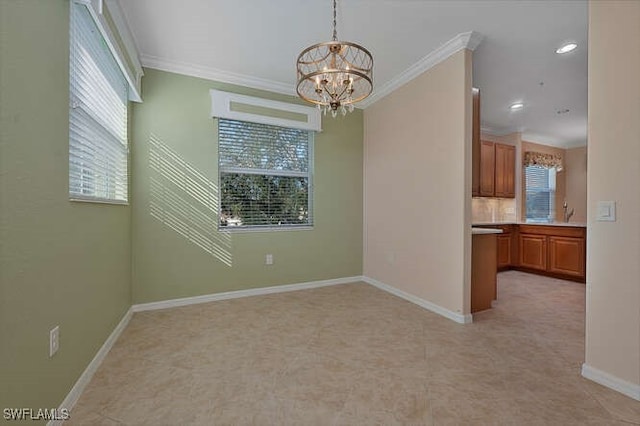 spare room with crown molding and a notable chandelier