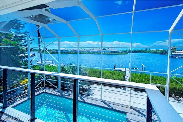 view of swimming pool featuring glass enclosure and a water view