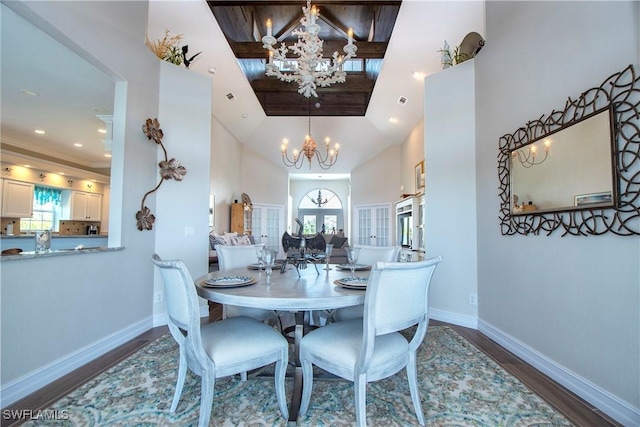 dining room featuring hardwood / wood-style flooring, a raised ceiling, ornamental molding, and an inviting chandelier