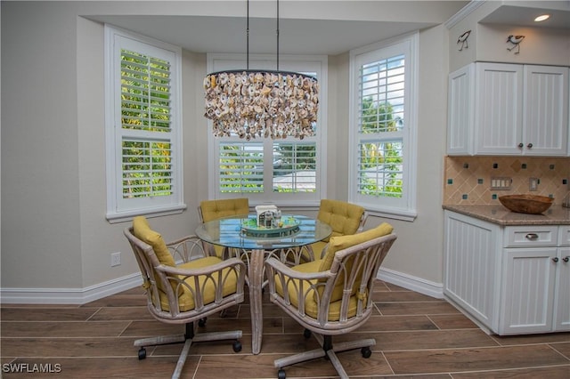 dining area featuring an inviting chandelier and dark wood-type flooring