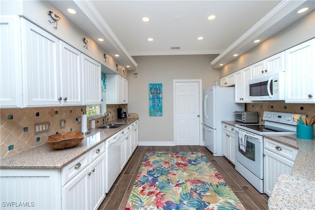 kitchen with decorative backsplash, white appliances, white cabinets, and sink