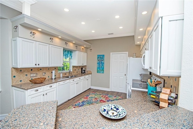 kitchen with white appliances, white cabinets, sink, decorative backsplash, and light stone countertops