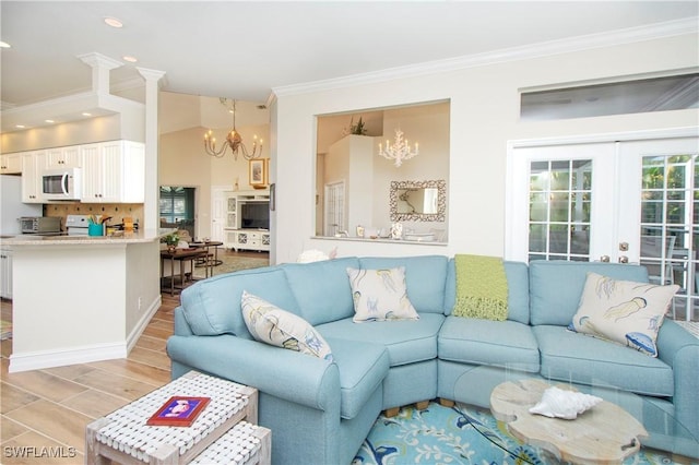 living room featuring french doors, a chandelier, light wood-type flooring, and ornamental molding