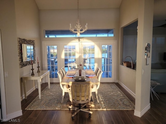 dining area featuring a wealth of natural light, dark hardwood / wood-style flooring, french doors, and a notable chandelier