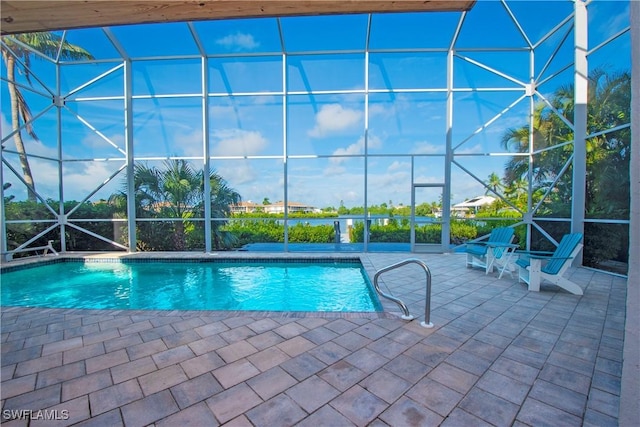 view of pool with glass enclosure and a patio area