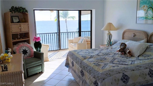 bedroom with access to exterior, light tile patterned floors, and a water view