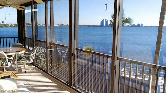 sunroom featuring a water view and ceiling fan