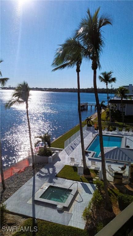 exterior space featuring a water view and a hot tub