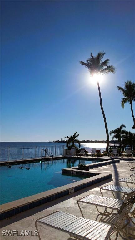 view of swimming pool with a water view and a patio