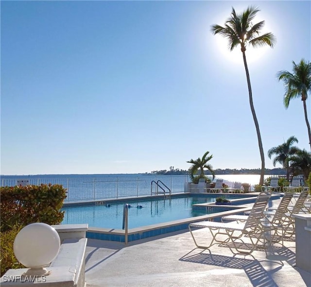 view of swimming pool with a patio and a water view