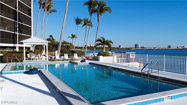 view of swimming pool with a water view and a patio area