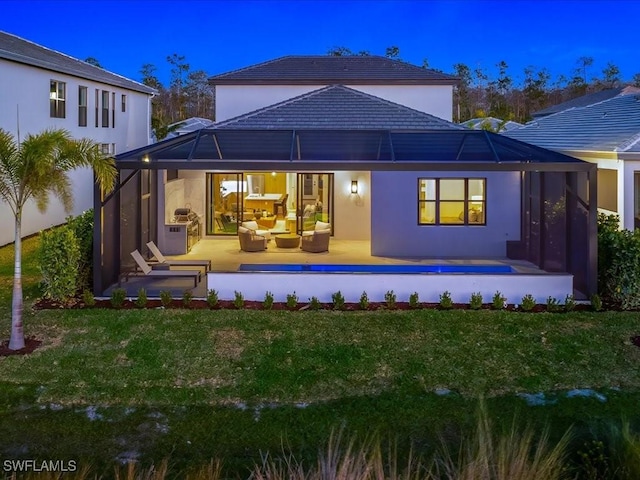 back of house with outdoor lounge area, a yard, a pool, and a patio area