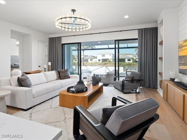 living room with a notable chandelier and light hardwood / wood-style flooring