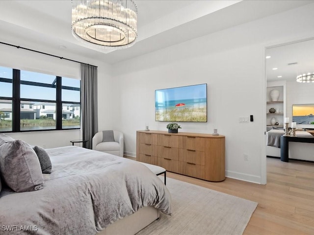 bedroom featuring light wood-type flooring and a notable chandelier