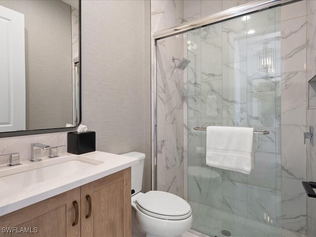 bathroom featuring vanity, toilet, and an enclosed shower