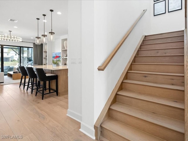 staircase featuring wood-type flooring and sink