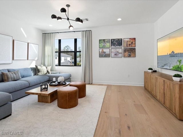 living room featuring a chandelier and light hardwood / wood-style floors